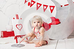 Portrait of a cute little baby girl in a decorated holiday studio of the Valentine`s day