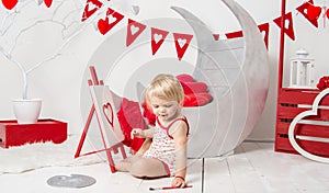 Portrait of a cute little baby girl in a decorated holiday studio of the Valentine`s day