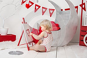 Portrait of a cute little baby girl in a decorated holiday studio of the Valentine`s day