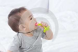 Portrait of cute little baby girl sitting with cozy on bed at bedroom, happiness of toddler.