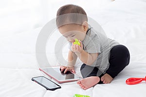 Portrait of cute little baby girl sitting with cozy on bed at bedroom, happiness of toddler.