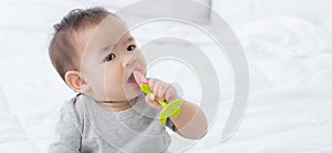 Portrait of cute little baby girl sitting with cozy on bed at bedroom, happiness of toddler.