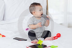 Portrait of cute little baby girl sitting with cozy on bed at bedroom, happiness of toddler, newborn 6-11 months.