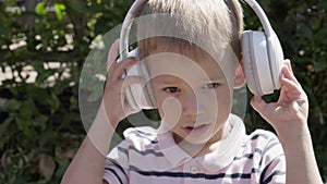 Portrait of Cute Little Boy With Headphones Listening to Music. Cheerful Carefree Childhood. Preschool Girl Feeling Free