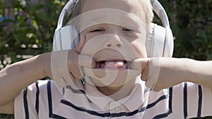 Portrait of Cute Little Boy With Headphones Listening to Music. Cheerful Carefree Childhood. Preschool Girl Feeling Free