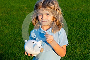 Portrait of cute little boy with piggy bank. Saving money concept. Kids with piggybank money box.