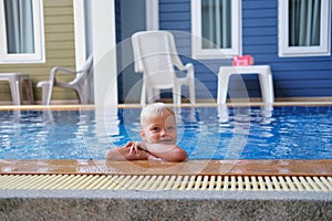 Portrait boy child in swimming pool home summer holiday, outdoors