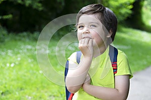 Portrait cute little boy putting his fingers in his mouth and looking at the camera with beautiful brown eyes, Excited kid carryin