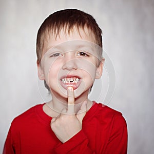 Portrait cute little Boy shows the First dropped-out milk Tooth