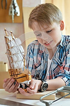 Portrait of cute little boy working with wood in workshop