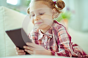 Portrait of cute little child girl with tablet at digital homeschooling