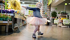 Portrait of cute little dancing girl in supermarket