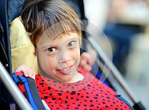 Portrait of a cute little disabled girl in a wheelchair. Child cerebral palsy. Inclusion