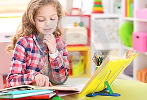 Portrait of cute little girl doing homework