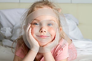 Portrait of cute little girl dreaming in bed