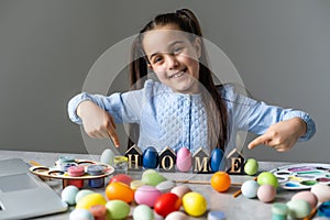 Portrait of a cute little girl dressed in Easter bunny ears holding colorful eggs.