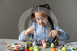 Portrait of a cute little girl dressed in Easter bunny ears holding colorful eggs.