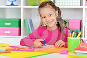 Portrait of cute little girl gluing paper photo