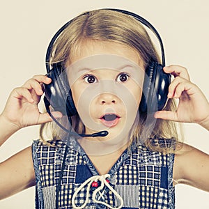 Portrait of cute little girl with headphones on her head