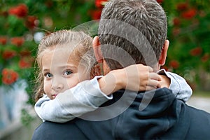 Portrait of cute little girl held in father arms. Happy loving family. Father and his daughter child girl playing hugging. Cute