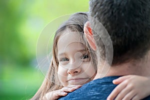 Portrait of cute little girl held in father arms. Happy loving family. Father and his daughter child girl playing hugging. Cute