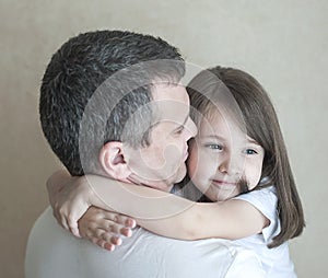 Portrait of cute little girl held in father`s arms. Happy loving family. Father and his daughter child girl playing hugging