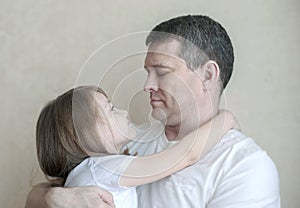 Portrait of cute little girl held in father`s arms. Happy loving family. Father and his daughter child girl playing hugging