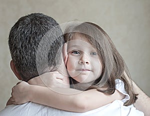 Portrait of cute little girl held in father`s arms. Happy loving family. Father and his daughter child girl playing hugging