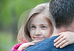 Portrait of cute little girl held in father`s arms. Happy loving family. Father and his daughter child girl playing hugging