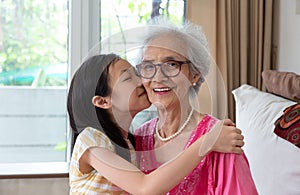 Portrait of cute little girl and her beautiful grandma sitting o