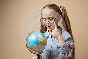 Little girl in glasses holding globe