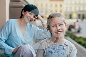 Portrait of cute little girl, mother in blurred background