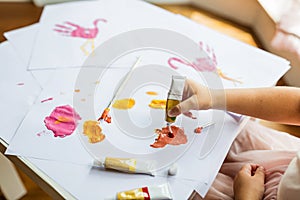 Portrait of a cute little girl painting hands at home. Learn, education, happy childhood concept