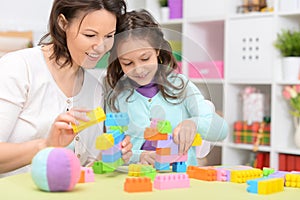 Portrait of cute little girl playing with colorful clay blocks