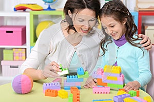 Portrait of cute little girl playing with colorful clay blocks