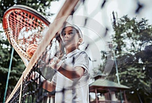 portrait of cute little girl playing tennis in summer