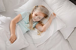 Portrait of cute little girl sleeping in large bed
