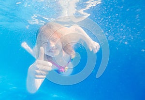 Portrait of a cute little girl swimming underwater