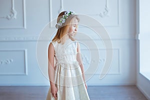 Portrait of a cute little girl in wreath of flowers