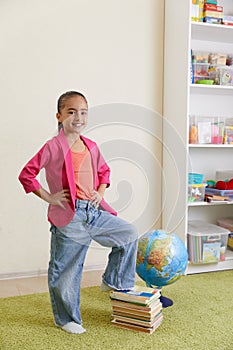 Portrait of cute little latin schoolgirl in classroom. Happy young latin girl wearing casual clothing