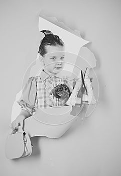 Portrait of a cute little pin-up girl in a beautiful dress, shoes and bag