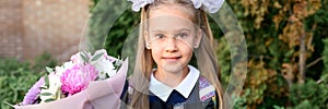 Portrait of a cute little seven year old first-grader girl with a bouquet of flowers ready to go to school. back to school concept