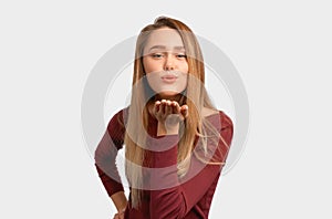 Portrait of cute lovely girl sending blowing kiss with pout lips looking at camera