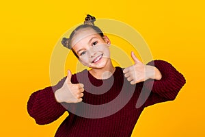 Portrait of cute lovely girl toothy smile arms fingers demonstrate thumb up  on yellow color background
