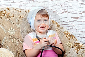 Portrait of cute miling child playing doctor or nurse with stethoscope