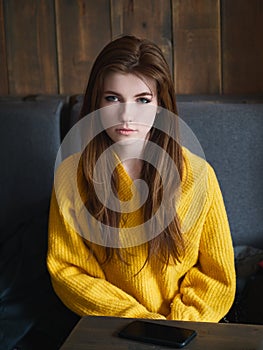 Portrait of a cute pretty redhead woman sitting in a cafe enjoying free time coffee break with a cup of cappuccino