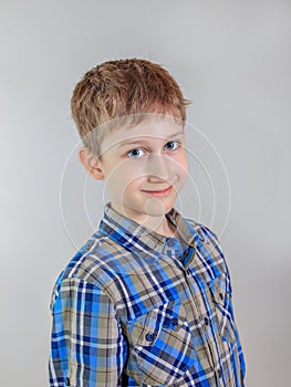 Portrait of cute redhead Ñaucasian boy, elementary school student on grey background