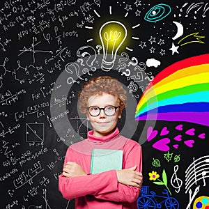 Portrait of cute redhead kid with light bulb. Curious child with colorful science and arts scetch. Kids education concept