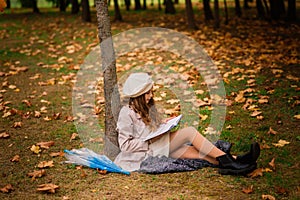 Portrait of cute schoolgirl with interesting book in natural environment