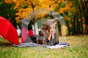 Portrait of cute schoolgirl with interesting book in natural environment